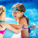 Two neighborhood children playing in the community swimming pool